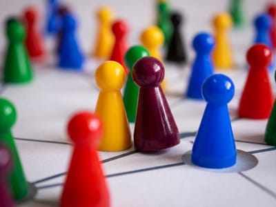 Colored game pawns standing on a paper network of drawn connecting lines